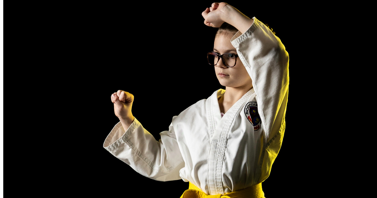 Young girl in a yellow belt practicing Taekwon-do stance with focus during belt test preparation at Phoenix Martial Arts