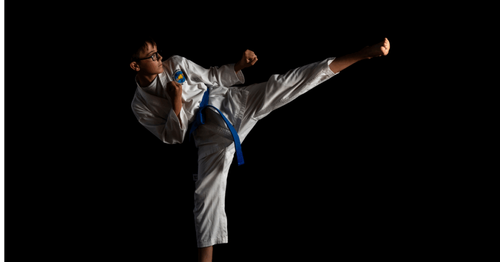 Shy kids turns into confident boy in Taekwon-do uniform performing a high side kick – Phoenix Martial Arts Edmonton