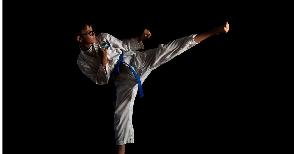 Shy kids turns into confident boy in Taekwon-do uniform performing a high side kick – Phoenix Martial Arts Edmonton