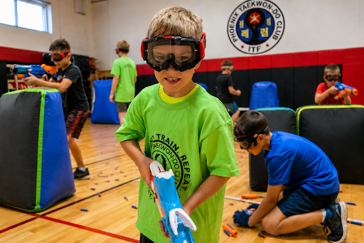 Child wearing safety goggles during the best kid summer camp the Ninja Nerf Camp at Phoenix Martial Arts Club near Spruce Grove and St. Albert with active summer camp games and teamwork.